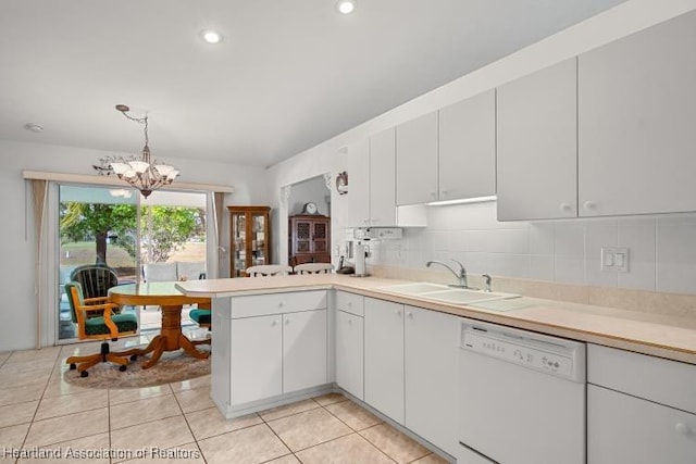 kitchen featuring light countertops, white dishwasher, decorative light fixtures, and a sink