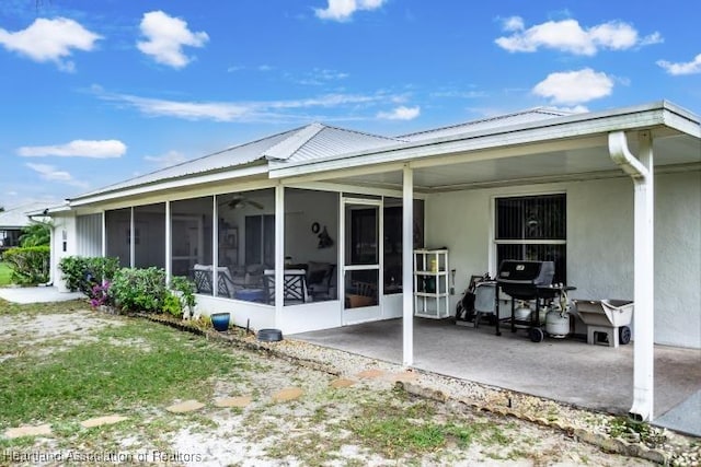 back of property with a patio area and a sunroom