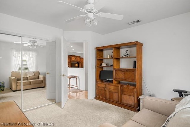 living room with light carpet, ceiling fan, and visible vents