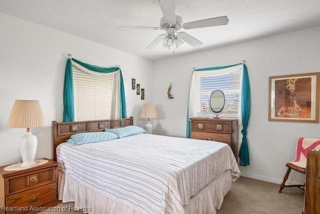 bedroom with ceiling fan, baseboards, and light colored carpet