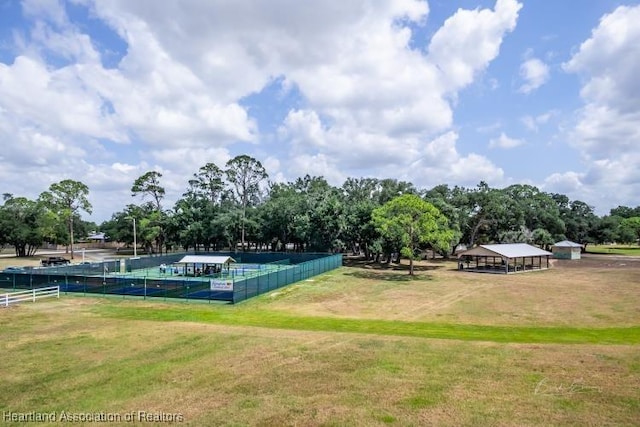 view of home's community with a yard and fence