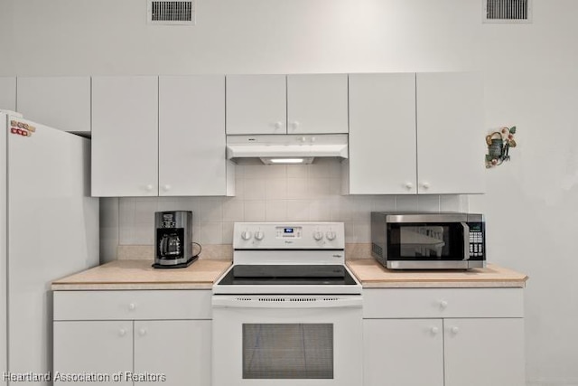 kitchen featuring visible vents, white appliances, light countertops, and under cabinet range hood