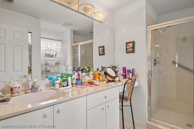 bathroom featuring visible vents, a shower stall, and vanity