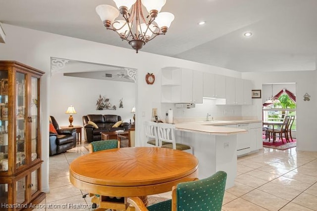 dining area with light tile patterned floors, a notable chandelier, and recessed lighting