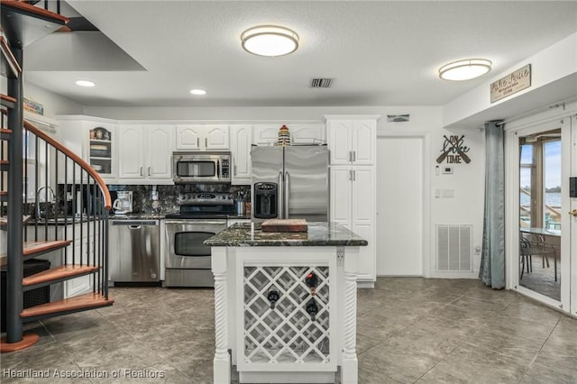 kitchen featuring white cabinetry, visible vents, appliances with stainless steel finishes, and tasteful backsplash
