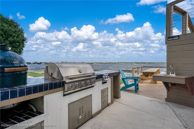 view of patio featuring area for grilling, a deck with water view, and grilling area