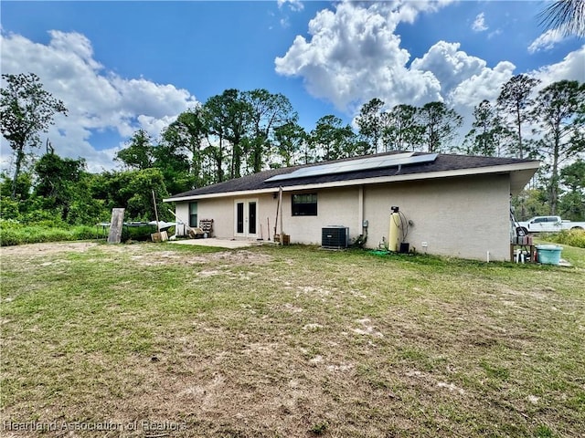 259 Condor Ave, Sebring, FL 33870 - rear view of house featuring central AC, french doors, solar panels, and a lawn