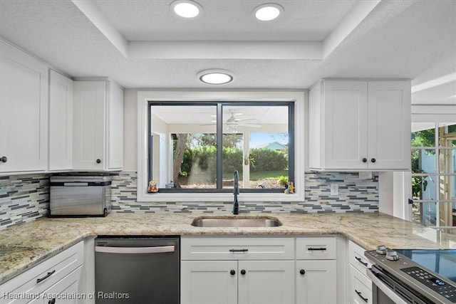 kitchen with appliances with stainless steel finishes, white cabinetry, a raised ceiling, and sink