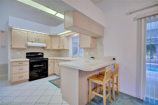kitchen featuring a kitchen breakfast bar, backsplash, black electric range oven, a peninsula, and under cabinet range hood