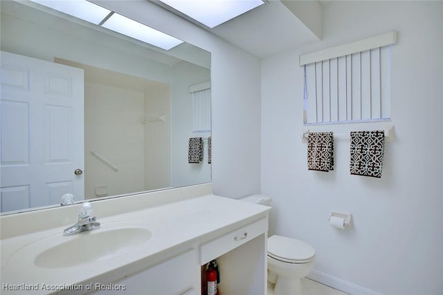 bathroom with vanity, baseboards, and toilet