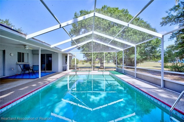 outdoor pool featuring a patio, a ceiling fan, and glass enclosure