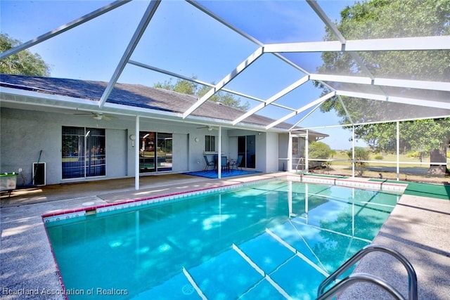 pool with a ceiling fan, glass enclosure, and a patio area