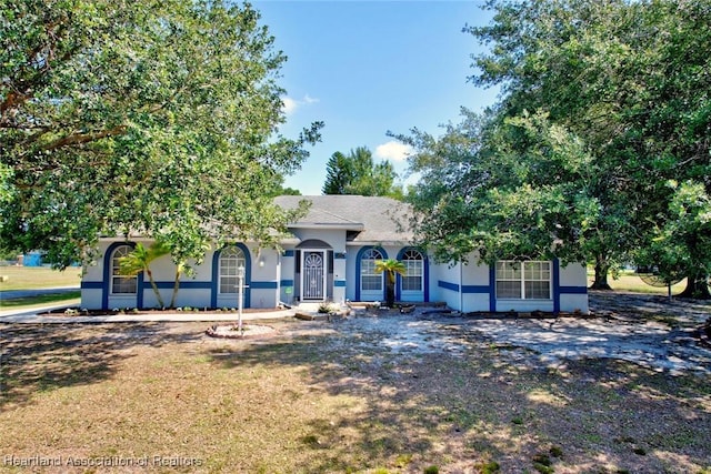view of front facade with stucco siding and a front yard