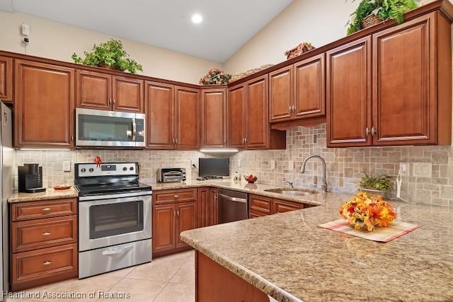 kitchen featuring decorative backsplash, light tile patterned floors, stainless steel appliances, and sink