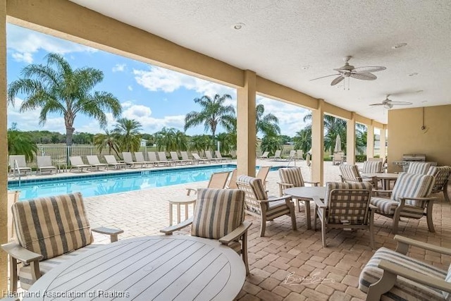 view of pool with ceiling fan and a patio