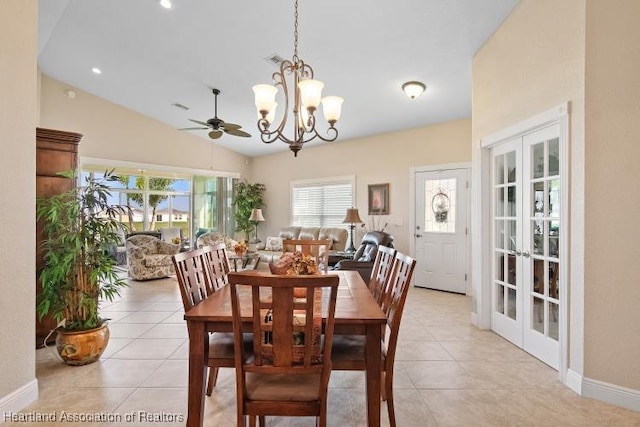 tiled dining space with ceiling fan with notable chandelier, lofted ceiling, and french doors