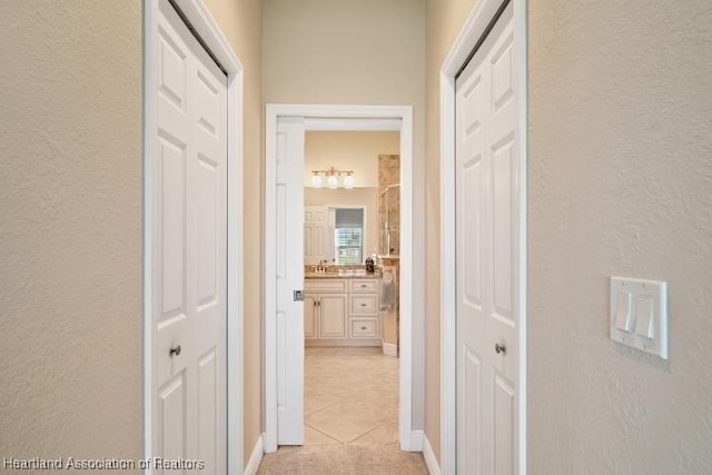 hallway featuring sink and light tile patterned floors