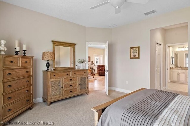 carpeted bedroom with ceiling fan and connected bathroom