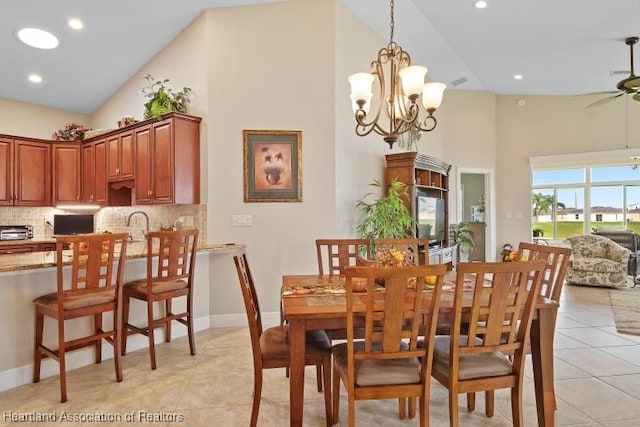 dining room featuring a notable chandelier, light tile patterned floors, and high vaulted ceiling