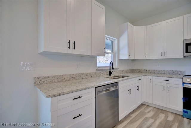 kitchen with light stone countertops, sink, white cabinetry, and stainless steel appliances