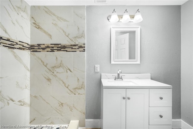 bathroom featuring vanity and a tile shower