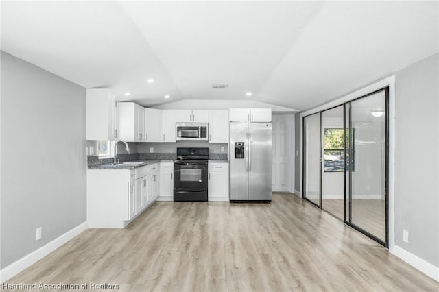 kitchen with appliances with stainless steel finishes, vaulted ceiling, sink, light hardwood / wood-style flooring, and white cabinets