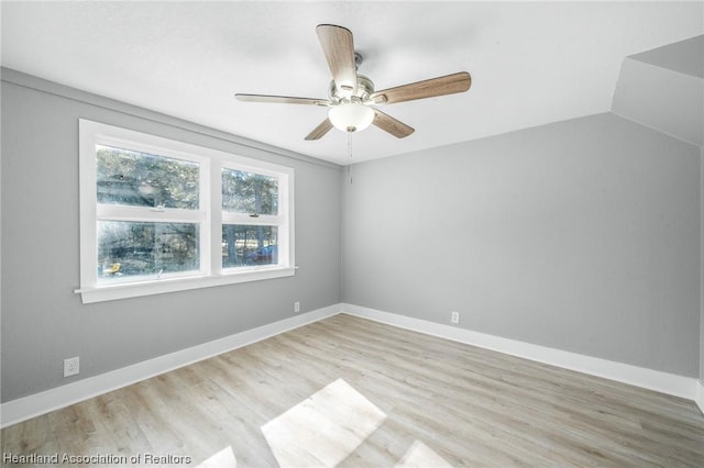 empty room featuring light hardwood / wood-style floors, vaulted ceiling, and ceiling fan