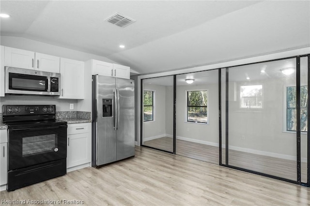 kitchen featuring light stone countertops, stainless steel appliances, vaulted ceiling, and white cabinetry