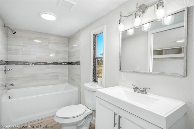 full bathroom with hardwood / wood-style floors, vanity, toilet, and tiled shower / bath