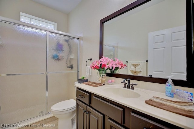 bathroom with toilet, vanity, tile patterned floors, and an enclosed shower