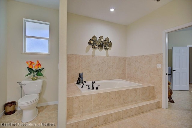 bathroom with tile patterned flooring, toilet, and tiled tub