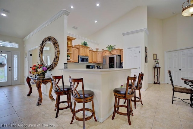 kitchen featuring a breakfast bar area, high vaulted ceiling, light tile patterned flooring, and appliances with stainless steel finishes