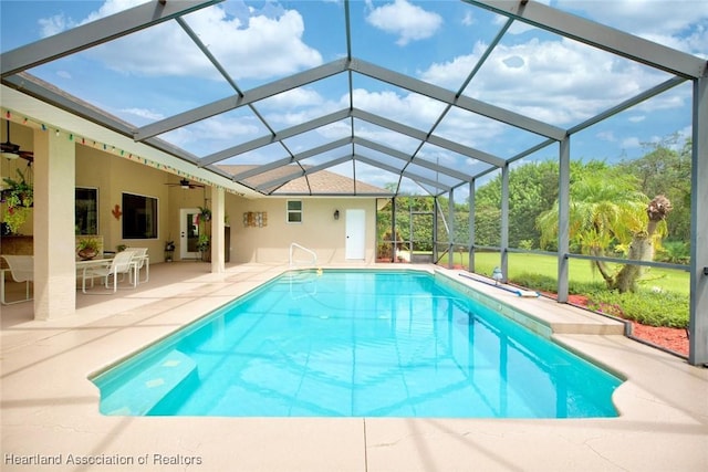 view of swimming pool featuring ceiling fan, a patio area, and glass enclosure