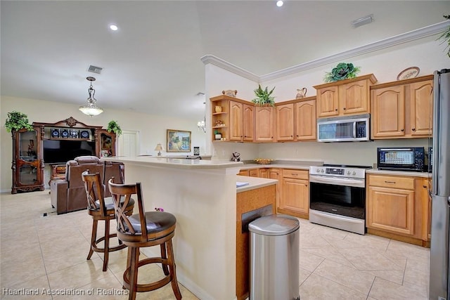 kitchen featuring kitchen peninsula, pendant lighting, a kitchen bar, light tile patterned floors, and appliances with stainless steel finishes