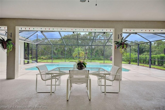 view of pool featuring glass enclosure and a patio area