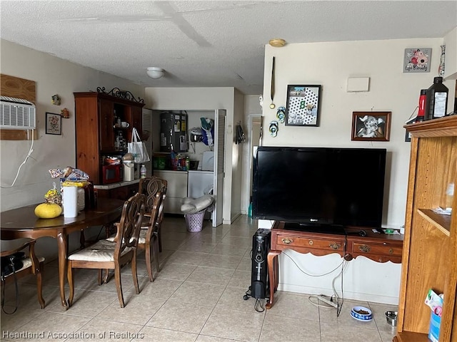 tiled dining area with a textured ceiling and washing machine and clothes dryer