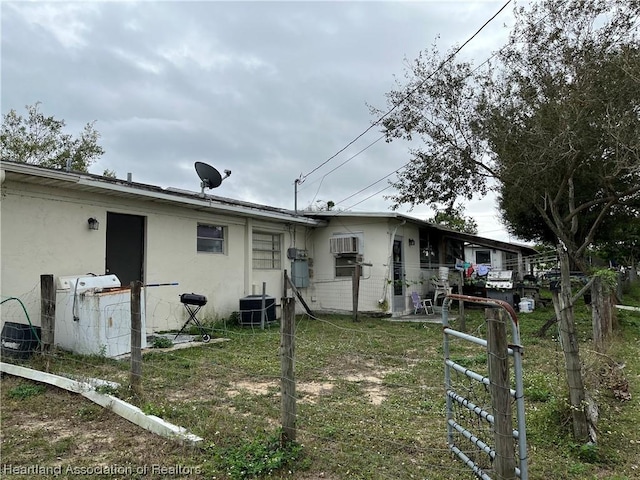 back of house with central AC unit