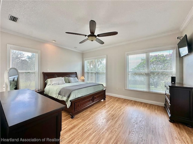 bedroom featuring multiple windows, light hardwood / wood-style flooring, ceiling fan, and ornamental molding