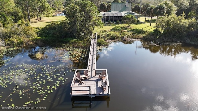 view of dock featuring a lawn and a water view