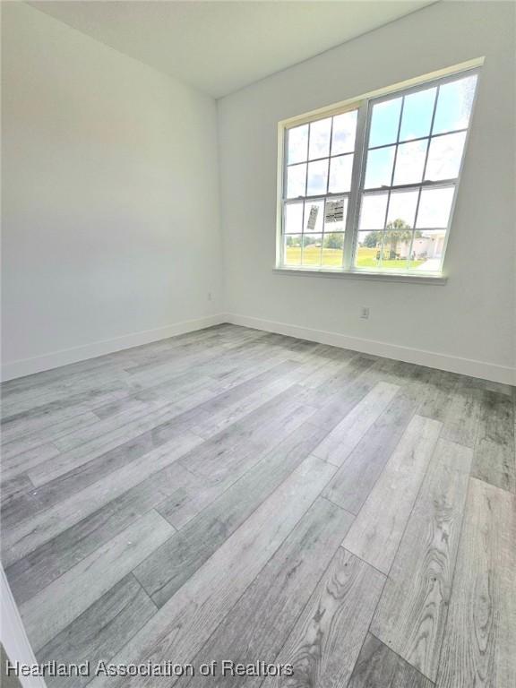 425 Floral Dr, Sebring, FL 33876 - unfurnished room featuring wood finished floors and baseboards