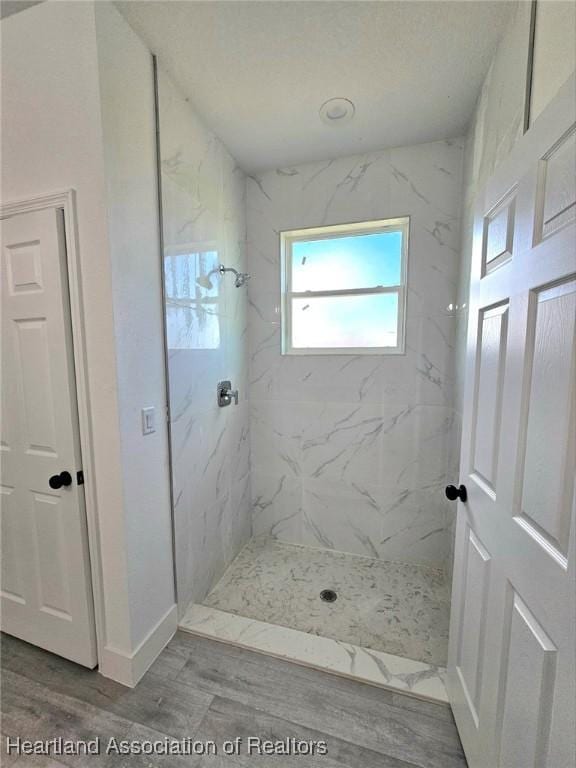 425 Floral Dr, Sebring, FL 33876 - full bath with a marble finish shower, wood finished floors, and baseboards