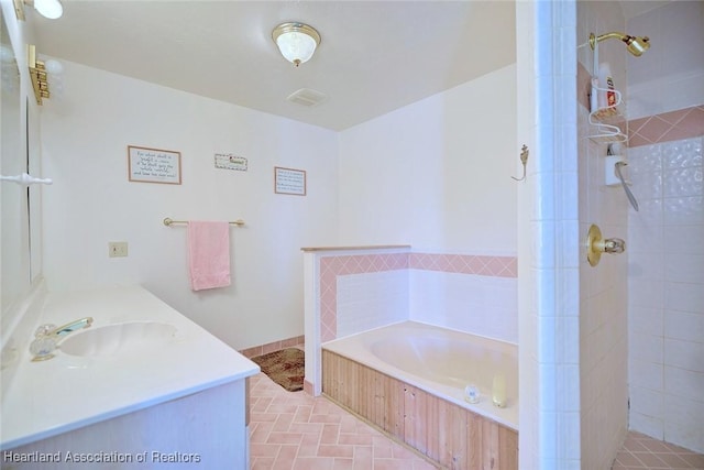 bathroom with vanity and shower with separate bathtub