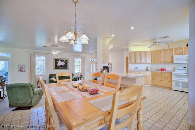 dining area with ceiling fan with notable chandelier and light tile patterned flooring