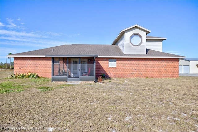 rear view of house featuring a sunroom and a yard