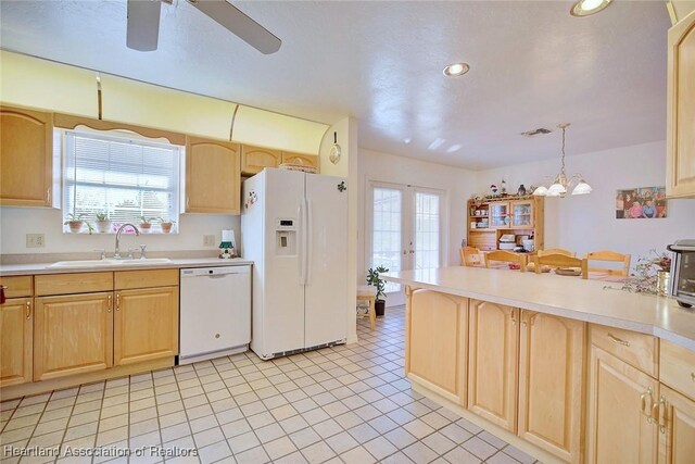 kitchen with pendant lighting, a healthy amount of sunlight, white appliances, and sink