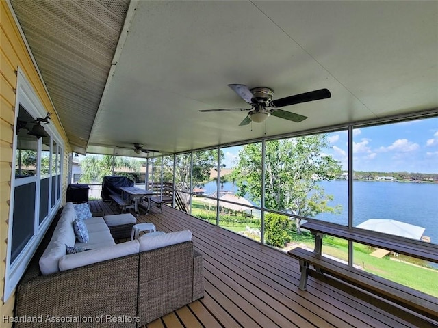 sunroom featuring a water view and ceiling fan