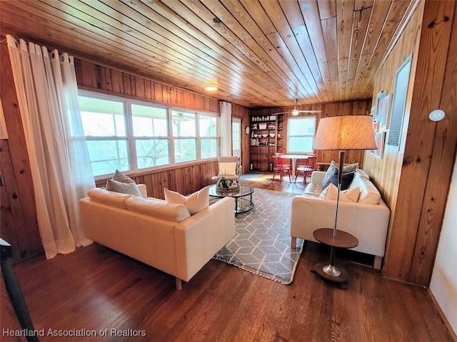 living room with wooden walls, dark hardwood / wood-style floors, and wooden ceiling