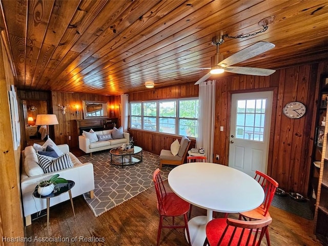 dining room featuring wood walls, ceiling fan, wood ceiling, and hardwood / wood-style flooring