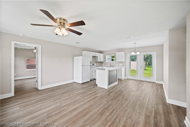 kitchen featuring pendant lighting, white cabinets, white refrigerator, light hardwood / wood-style flooring, and a kitchen island