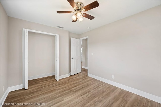 unfurnished bedroom featuring ceiling fan, a closet, and light hardwood / wood-style floors